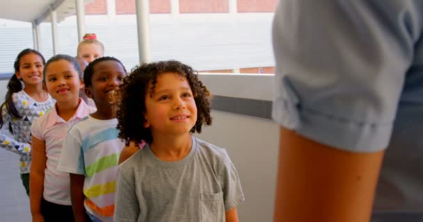 一群不同的小学生的前面的看法 老师在学校的走廊里排队 他们4K — 图库视频影像