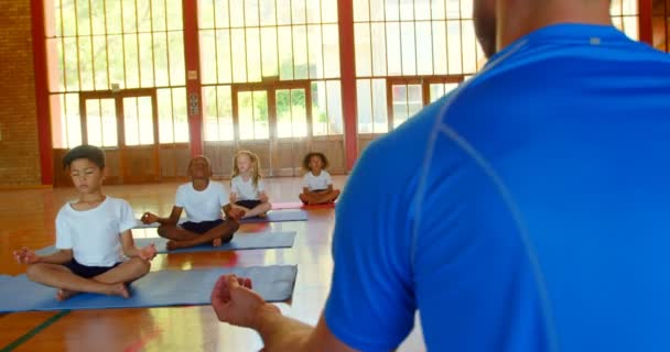 Bakifrån Kaukasiska Mansperson Yogainstruktör Undervisning Yoga Till Skolbarnen Skolan — Stockvideo