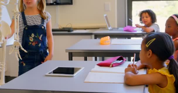 Vooraanzicht Van Cute Kaukasisch School Meisje Uit Leggen Menselijk Skeletmodel — Stockvideo