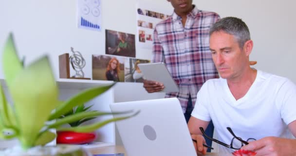 近代的なオフィスにデジタル タブレット上を議論する多民族ビジネス同僚のフロント ビュー の机に座って白人男性エグゼクティブ — ストック動画