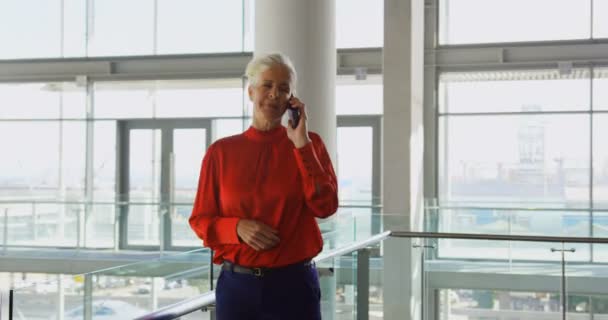 職場で携帯電話で話す白人ビジネスウーマンの側面 彼女はバルコニーに立っている — ストック動画