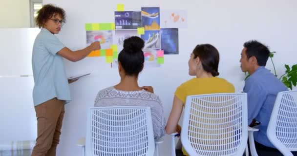 Vista Lateral Hansome Joven Mestizo Ejecutivo Masculino Explicando Sobre Gráficos — Vídeos de Stock