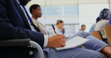 Onun not etmek üstünde iş Semineri 4 k katılırken yazma bir karma yarış işadamı yan görünüm