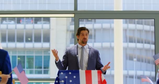一位白人男性演讲者在商业研讨会上高举美国国旗对公众讲话的正面观点 — 图库视频影像