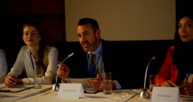 Olgun Kafkas işadamının ön görünümü oditoryumda iş seminerinde konuşuyor. O gülümsüyor ve dijital tablet tutarak 