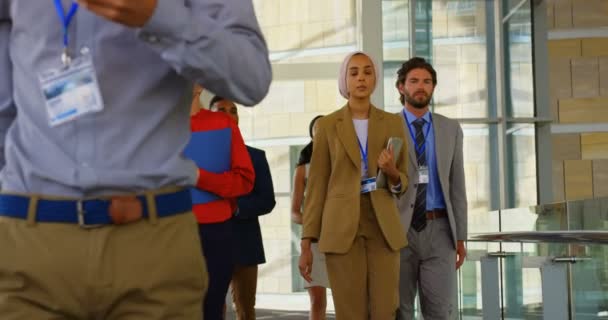 オフィスビル ビジネス セミナーに出席するため廊下を歩きのマルチ民族のビジネス人々 のグループの正面図 — ストック動画