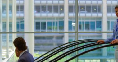 Yan görünümü çok etnik iş adamları ile her diğer Office 4 k yürüyen merdiven üzerinde taşırken etkileşim