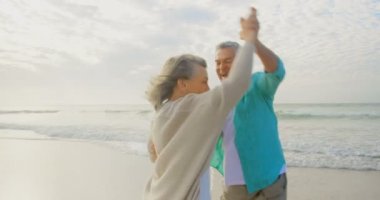 Ve birlikte güneşli bir günde 4 k kumsalda dans eğlenceli sahip bir etkin üst düzey beyaz çift önden görünümü