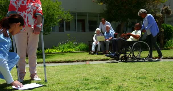 Πλευρική Όψη Της Γυναίκας Γιατρού Που Εξετάζει Τον Ανώτερο Ασθενή — Αρχείο Βίντεο