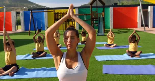 Vista Frontal Profesora Enseñando Los Escolares Realizar Yoga Patio Recreo — Vídeos de Stock