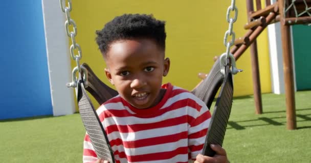 Front View African American Schoolboy Playing Swing School Playground Looking Video Clip