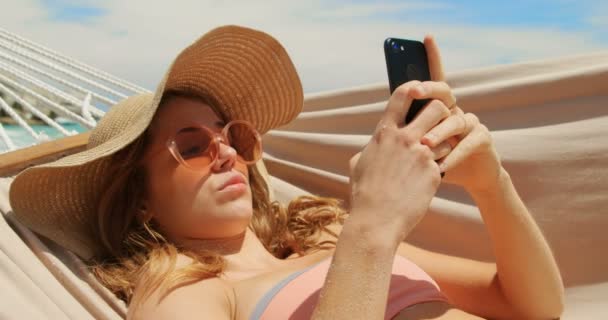 Вид Сбоку Белую Женщину Мобильного Телефона Гамаке Пляже Расслабляется Улыбается — стоковое видео