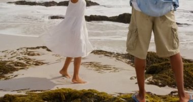 Sahilde cep telefonu ile kadın fotoğrafları tıklayarak Afrikalı Amerikalı adam Arka görünümü. Kadın poz ve dans 4k