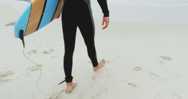男子冲浪手与冲浪板在海滩上散步的比例较低 他准备好冲浪4K了 — 图库视频影像