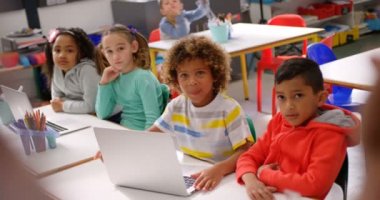 Erkek öğretmen sınıfta ki çocuklara ders veriyor. Okul çocuğu ellerini kaldırıyor 