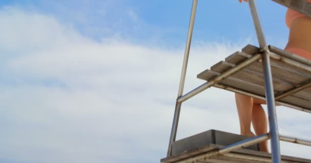 Vista Ángulo Bajo Mujer Sentada Torre Observación Playa — Vídeos de Stock