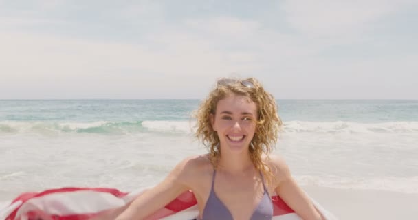 Вид Спереди Белой Женщины Размахивающим Американским Флагом Танцующей Пляже Улыбается — стоковое видео