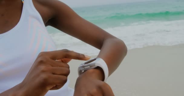 Vorderansicht Einer Afrikanisch Amerikanischen Frau Die Strand Eine Smartwatch Benutzt — Stockvideo