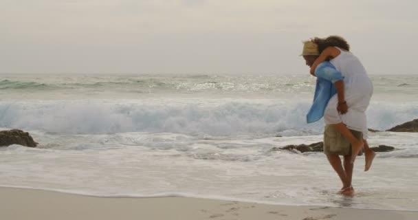 African American Man Geeft Piggyback Ride Naar Vrouw Het Strand — Stockvideo