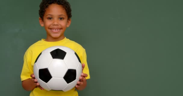 Sınıfta Tebeşir Tahtasıkarşı Futbol Ile Ayakta Afro Amerikan Okul Çocuğu — Stok video
