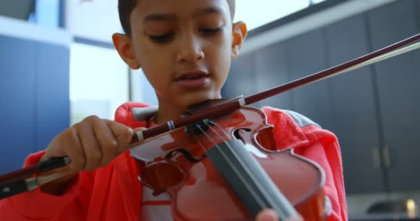 학교에서 교실에서 바이올린을 연주하는 세심한 아시아 남학생의 정면보기 4K를 배우고있다 — 비디오