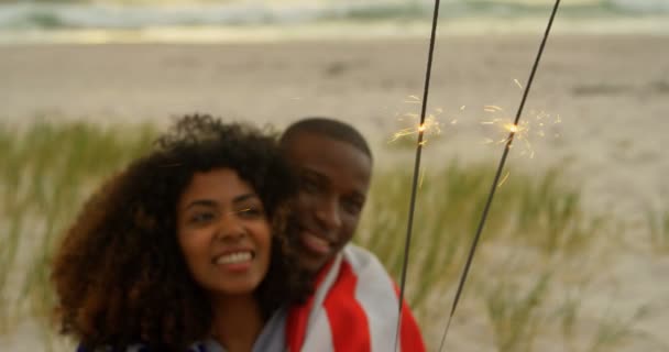 前视图的非洲裔美国夫妇在海滩手中拿着火花 他们有乐趣 — 图库视频影像