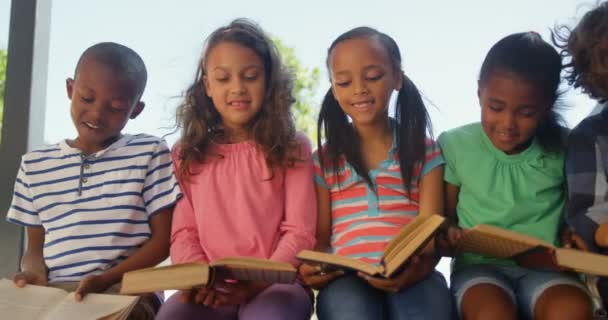 Вид Спереди Школьников Смешанной Расы Читающих Книги Коридоре Сидят Вместе — стоковое видео