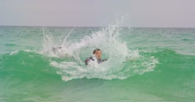 Sahilde denizde evrak çantasıyla dans eden Kafkas işadamının ön görünümü. O eğleniyor 4k