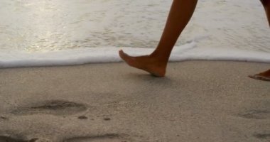 Sahilde koşan bir kadın. Arka planda deniz sörfü 4k