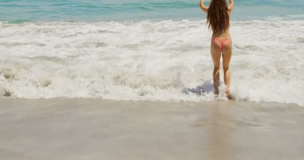 Vista Trasera Mujer Caucásica Divirtiéndose Playa Ella Está Saltando — Vídeo de stock