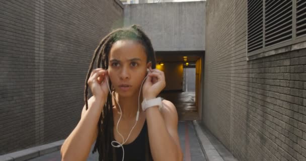 非裔美国人妇女在城市慢跑的正面景色 她正在听音乐4K — 图库视频影像