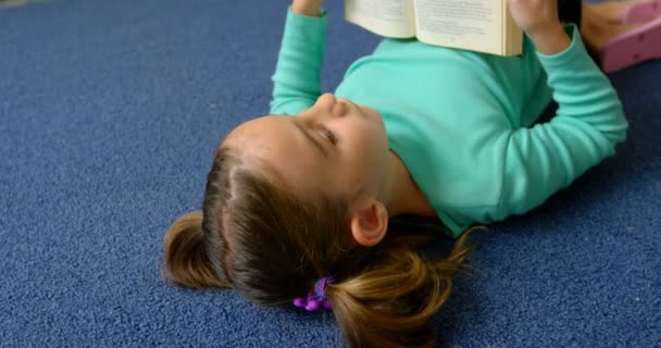 Vista Frontal Estudante Caucasiana Atenta Lendo Livro Biblioteca Escola Ela — Vídeo de Stock