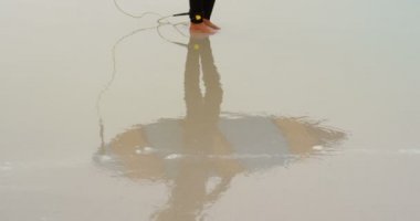 Sahilde duran sörf tahtası ile aktif üst düzey Afrikalı-Amerikalı kadın sörfçü Yan görünümü. O deniz 4k bakıyor