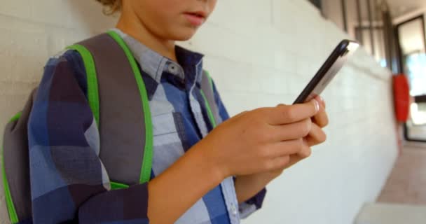 Πλευρική Όψη Του Καυκάσιου Μαθητού Χρησιμοποιώντας Κινητό Τηλέφωνο Ενώ Γέρνει — Αρχείο Βίντεο