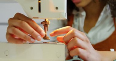 Atölyede dikiş makinesi ile çalışan Afrikalı Amerikalı kadın moda tasarımcısı ön görünümü. O dikiş makinesi 4k iplik koyarak