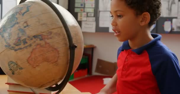 Zijaanzicht Van African American School Boy Studeert Globe Bij Desk — Stockvideo