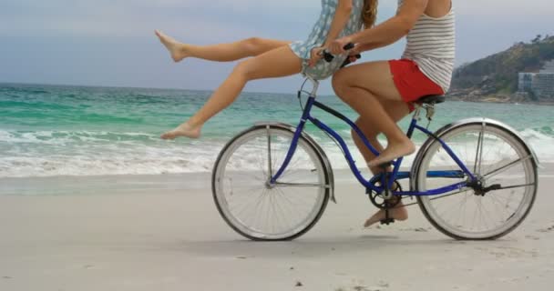 ビーチで自転車に乗る白人カップルの側面図 4Kで一緒に過ごす — ストック動画