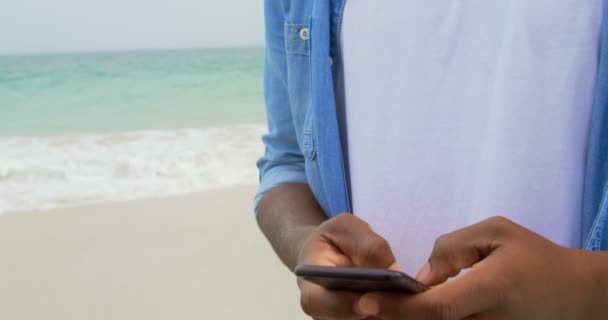 Vista Lateral Del Hombre Afroamericano Usando Teléfono Móvil Playa Está — Vídeo de stock