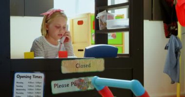 Bill Counter'da yönetici gibi davranan Beyaz kız öğrencinin ön görünümü. O oyuncak telefon 4k konuşuyor