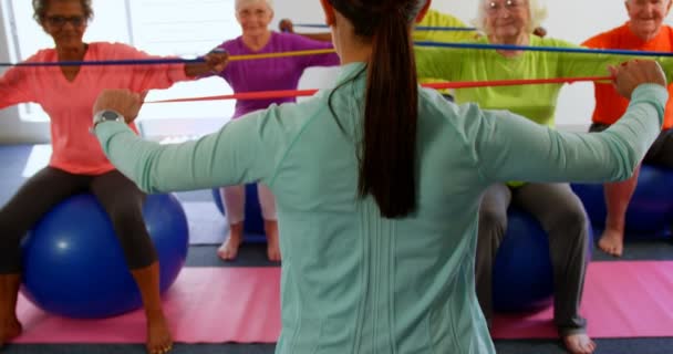 Achteraanzicht Van Vrouwelijke Trainer Training Senior Mensen Oefening Fitness Studio — Stockvideo