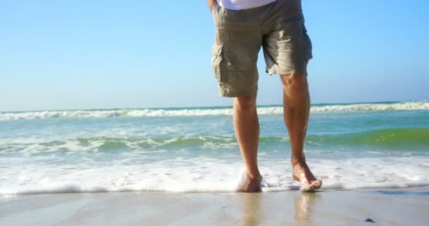 低段活跃的老人走在沙滩上 海浪触摸他的脚4K — 图库视频影像