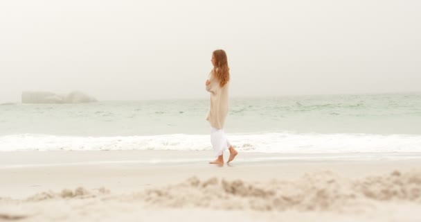 Vista Lateral Mujer Caucásica Caminando Por Playa Ella Está Envuelta — Vídeo de stock