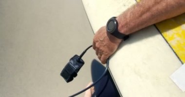 Erkek sörfçü plajda sörf tahtası ile yürüyüş orta bölümü. O sahilde 4k yürüyor