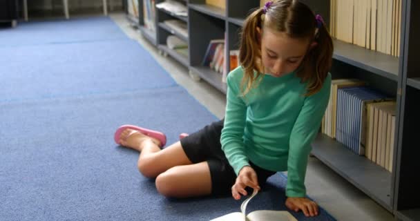 Framifrån Uppmärksam Kaukasisk Skolflicka Läsa Bok Biblioteket Skolan Hon Sitter — Stockvideo