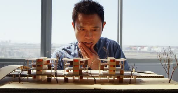 Vista Frontal Del Arquitecto Masculino Asiático Mirando Modelo Arquitectónico Una — Vídeo de stock