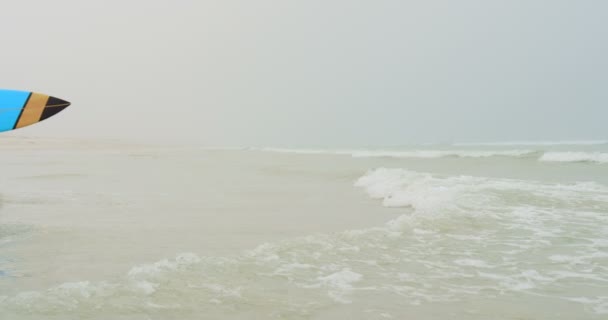 活跃高级非洲裔美国女冲浪者在沙滩上奔向大海的侧视图 她拿着冲浪板4K — 图库视频影像