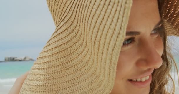Sahilde Şapkalı Mutlu Beyaz Bir Kadının Yakın Çekim Gülümsüyor Uzağa — Stok video