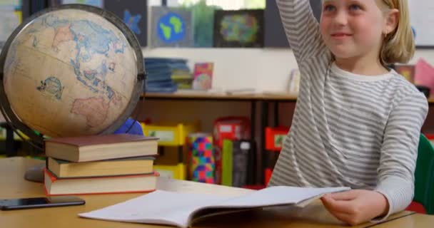 Beyaz Kız Öğrencinin Okulda Sınıfta Masaya Kaldırmasının Görünümü Gülümsüyor Bakıyor — Stok video
