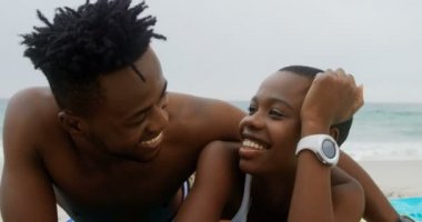 Sahilde dinlenen Afrikalı-Amerikalı çift ön görünümü. Birlikte vakit geçiriyorlar 4k