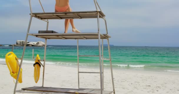 Visão Traseira Mulher Sentada Torre Observação Praia Ela Está Olhando — Vídeo de Stock